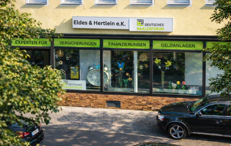 Bürogebäude mit grüner Beschilderung und Schaufenster in der Stadt.